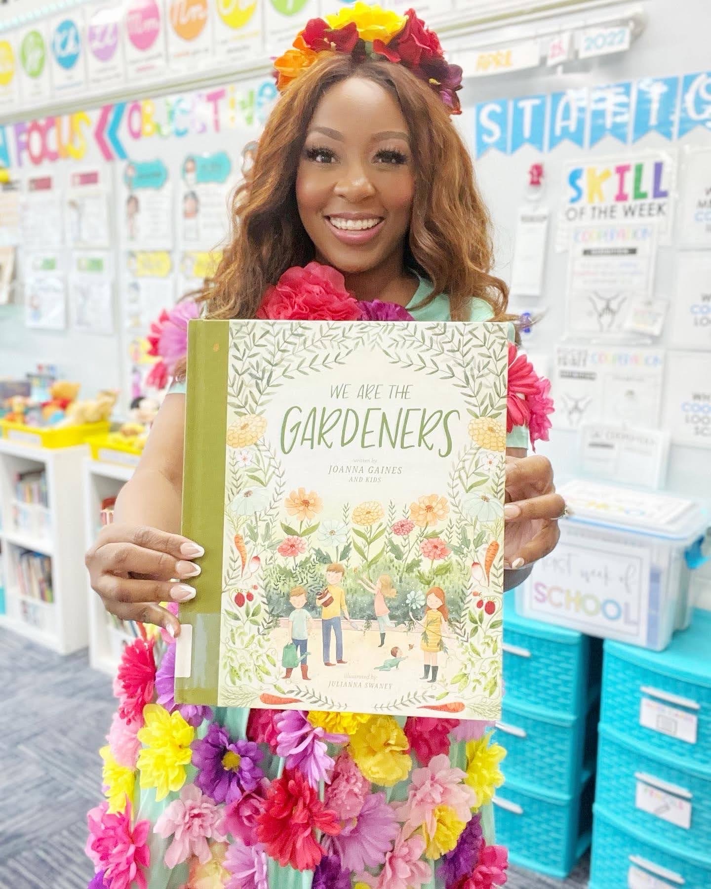 Patrice Jenkins holding We Are the Gardeners in her classroom