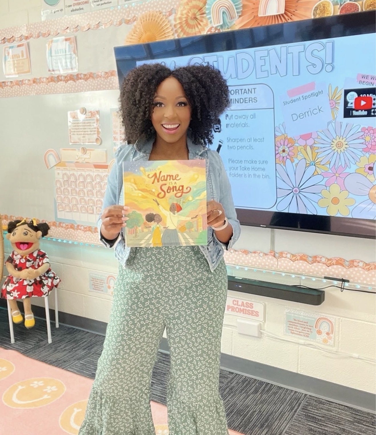 Patrice holding Your Name Is a Song in her classroom