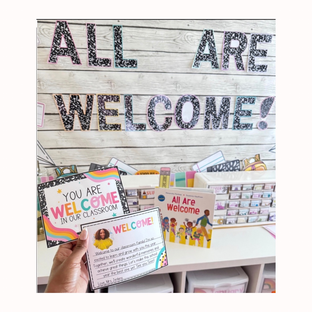 Classroom bulletin board All Are Welcome with postcards and book